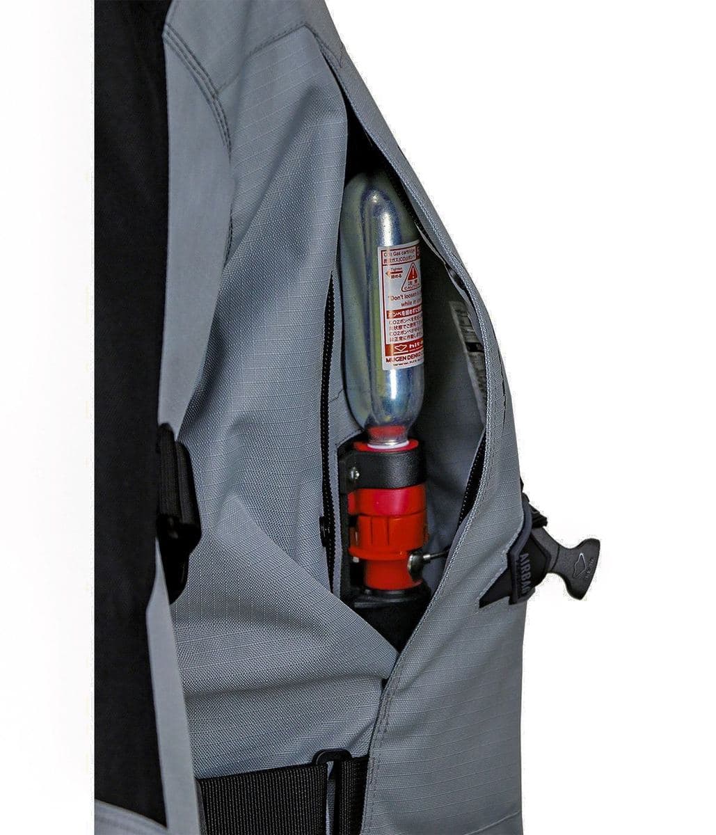 Caja de llave con cartucho de CO2 de 50cc, integrada de forma discreta bajo cremallera en el costado de la chaqueta.